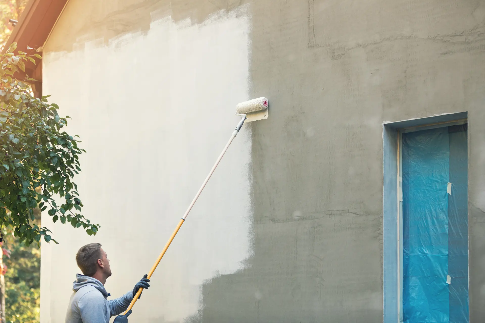 Pintor trabajando en una fachada en El Ejido